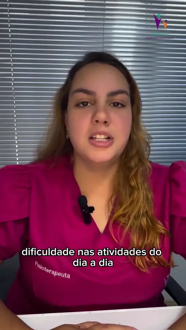 Fisioterapeuta de blusa rosa falando diante da câmera. A legenda na tela diz “dificuldade nas atividades do”.