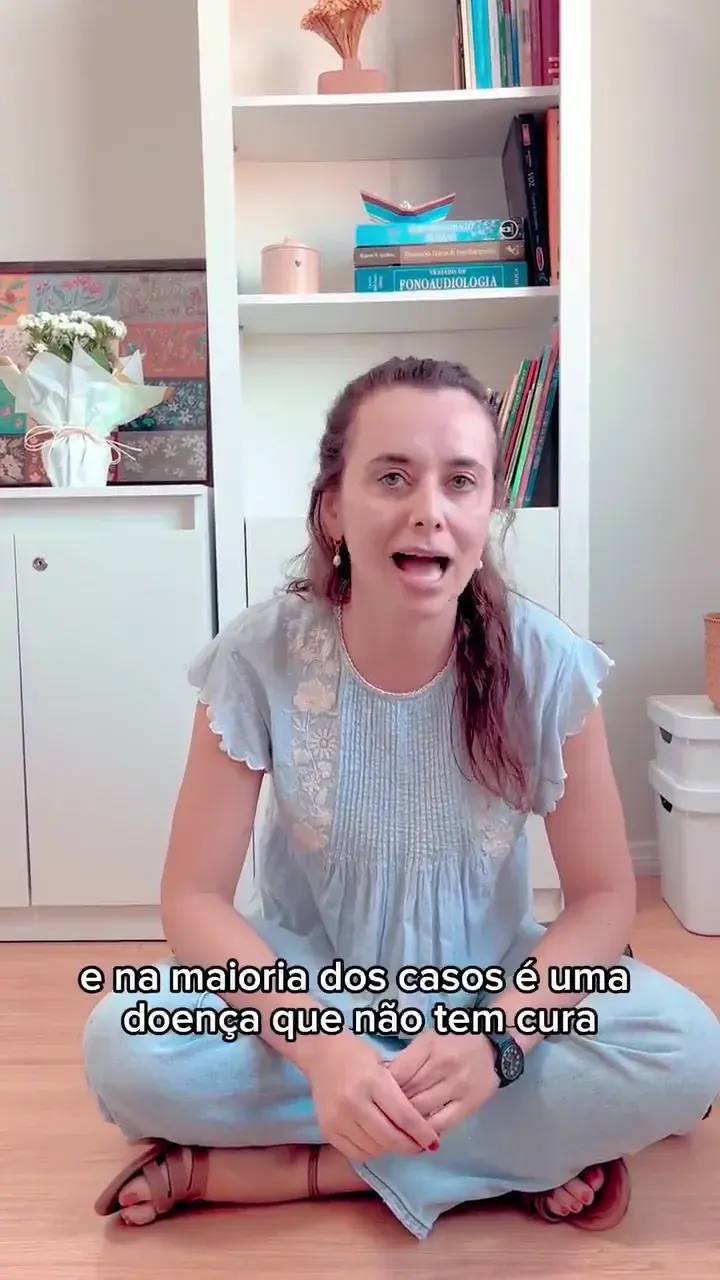 Fonoaudióloga falando diante da câmera, com uma estante de livros ao fundo. A legenda na tela diz “e na maioria dos casos é uma”.